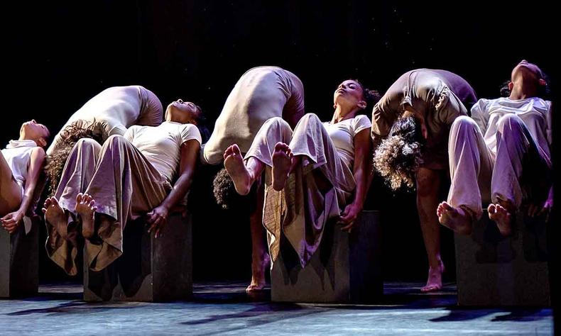 Bailarinos perfilados no palco, com as pernas escolhidas, no espetculo Bicho no concreto 