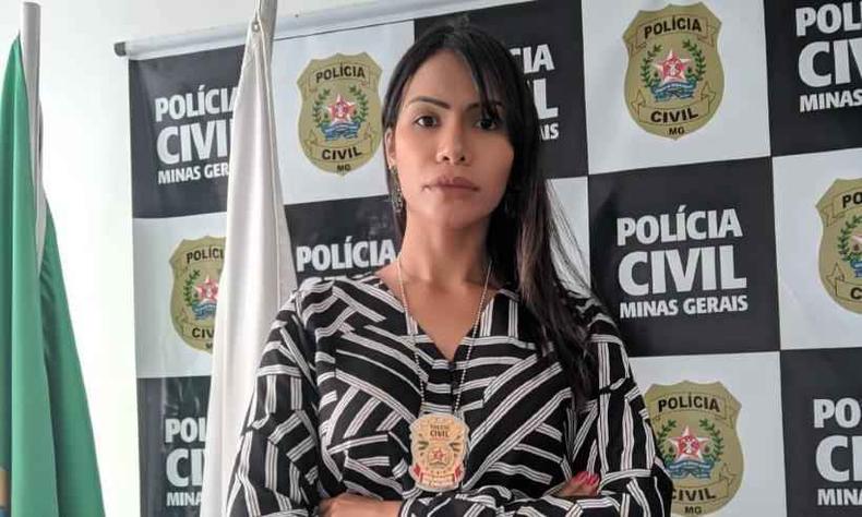 Ariadne Coelho  uma mulher de cabelos longos e lisos. Ela posa sria para a cmera com seu distintivo pendurado no pescoo. Ao fundo, est o painel da PCMG