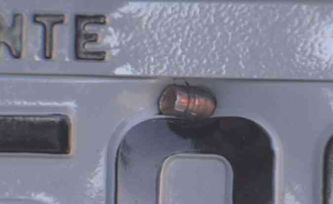 A bala que acertou a placa do carro importado do promotor de Justia(foto: Reproduo/TVA)