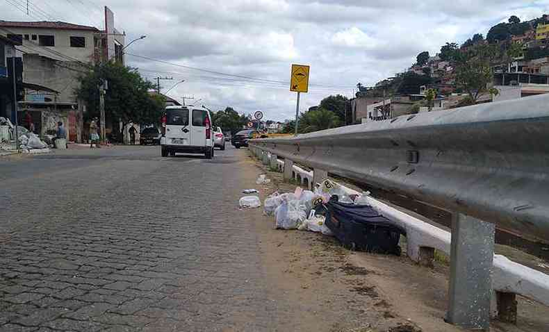 As sacolas de lixo ficam espalhadas de um lado e do outro da Avenida Tancredo Neves, no Bairro Santa Efignia