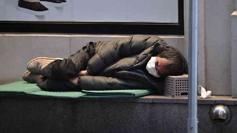Homem sem-teto dorme na calada da cidade de Daegu