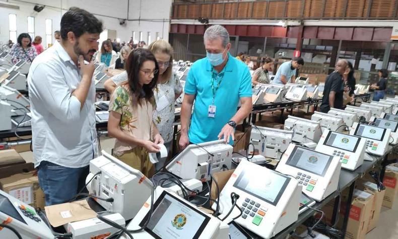 Neste primeiro dia, foram 731 urnas concluídas pela manhã e outras 756 na parte da tarde(foto: Jair Amaral/EM/D.A. Press) Funcionários do TRE-MG fazem procedimento nas urnas eletrônicas em um galpão do Centro de Apoio