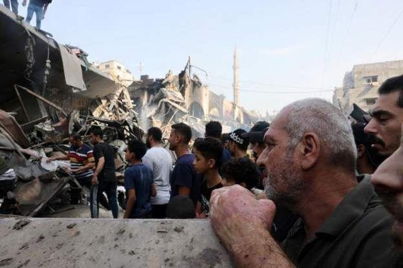 Palestinos em meio a runas de edifcio destrudo por ataque areo israelense na noite de sexta-feira, 27 de outubro, no norte de Gaza
