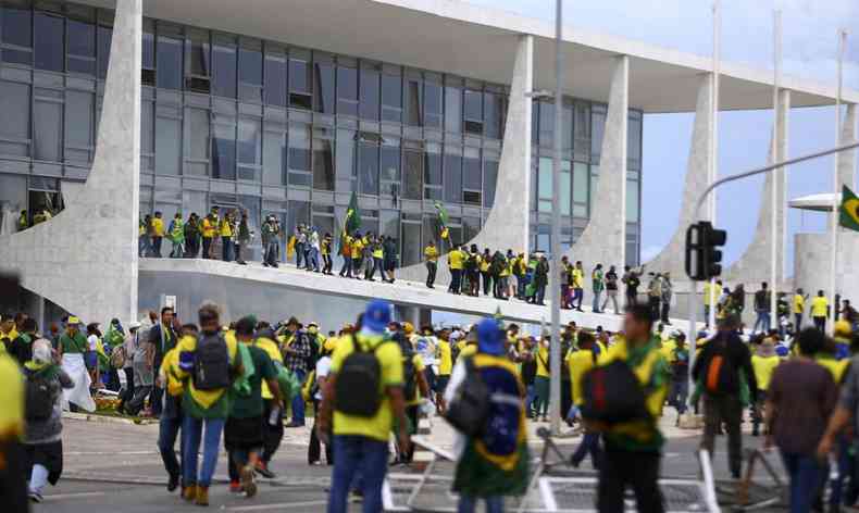 pessoal vestindo a bandeira do brasil e diante do palcio dos trs poderes