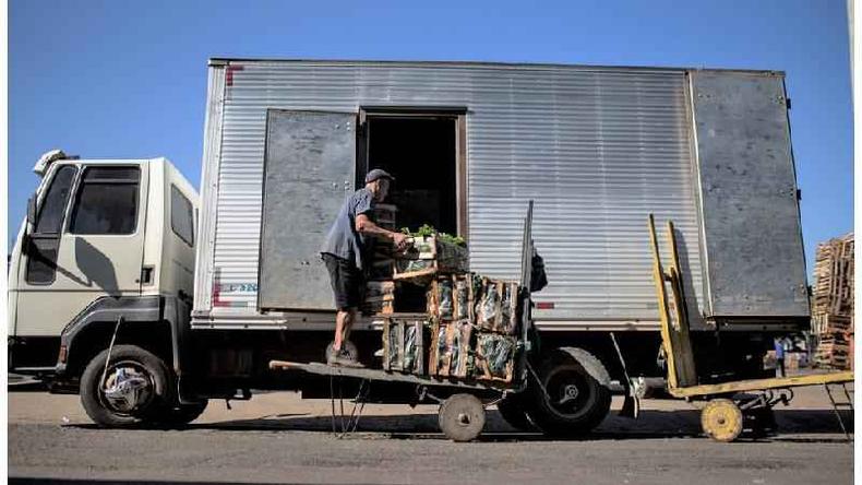 Caminhoneiro colocando produtos no veculo