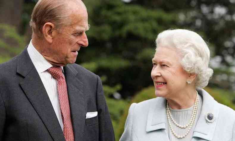 Princípe Philip e rainha Elizabeth se olham e sorriem