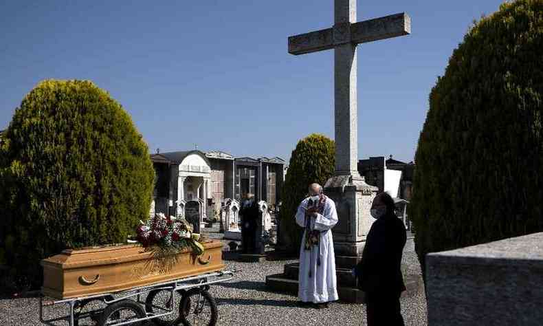 Padrefaz rito funerrio e as oraes durante enterro de vtima do COVID-19 no cemitrio de Envie, noroeste da Itlia(foto: MARCO BERTORELLO / AFP)