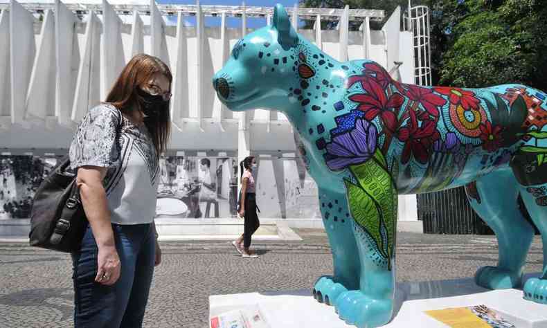 moradora admiram escultura de onça-pintada colorida em frente ao Palácio das Artes, em BH