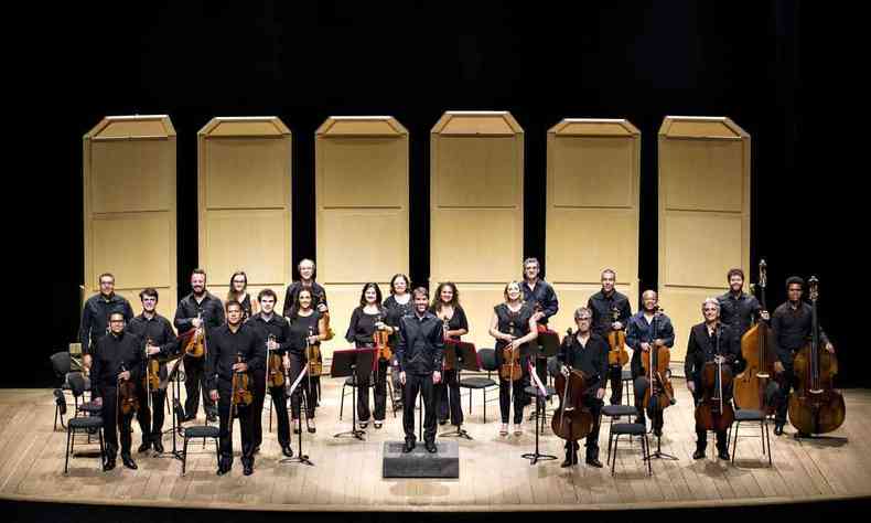 De roupas pretas, integrantes da Orquestra de Cmara Sesiminas posam com seus instrumentos, no palco do Teatro Sesiminas