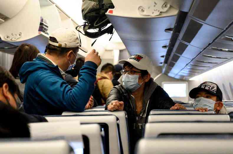 Chineses usam máscaras na chegada de voo em aeroporto de Xangai (foto: NOEL CELIS/AFP )