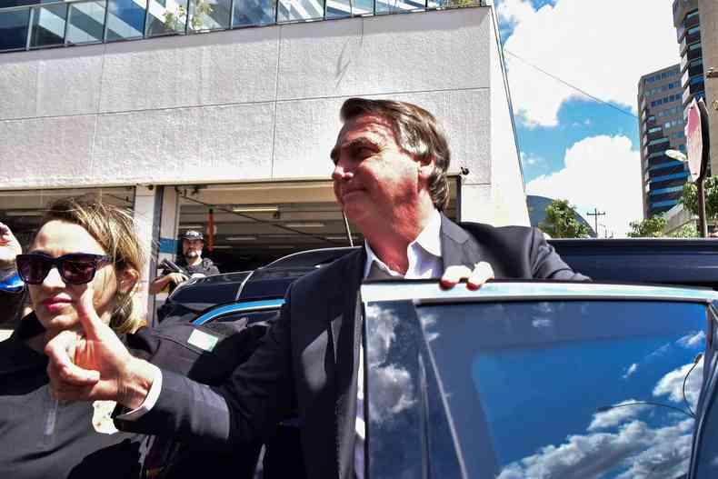 Bolsonaro dando joinha enquanto entra em um carro preto 