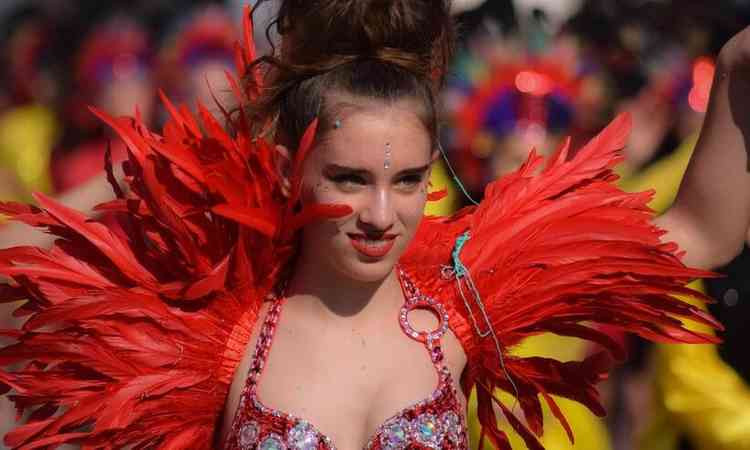 mulher de fantasia vermelha, com penas e brilho para o carnaval