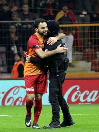 Jogador do time Galatasaray Spor Kulb, de Istambul, abraa policial depois de fazer gol em jogo neste domingo(foto: STR)