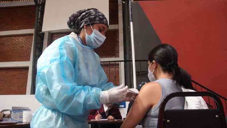Profissional de sade vacina uma mulher no Equador