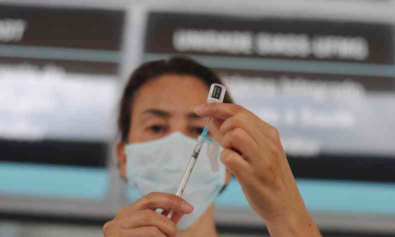 Enfermeira segurando seringa de vacina 