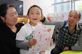 Guo posa ao lado dos pais: prtese d aparncia normal ao garoto(foto: C-mer Dennis Lam Eye Hospital/AFP Photo)