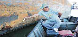 Pescador Onildo Dantas mostra ferrugem e outros danos causados nas embarcações por mexilhões(foto: Beto Novaes/EM/D.A Press)
