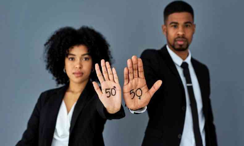 Homem e mulher jovens negros de terno com a mo estendida onde est escrito 50