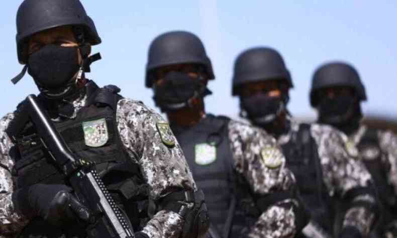 Agentes da Fora nacional com roupa camuflada, capacete, armas e mscara 