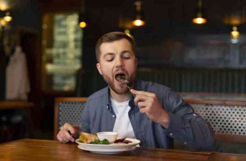 Homem comendo com a boca aberta