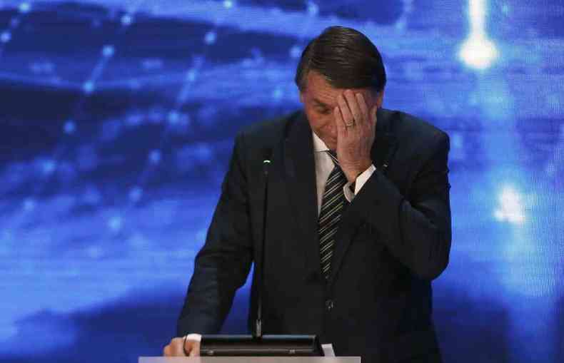 Bolsonaro leva a mo ao rosto, com aparncia cansada, durante debate da Banda