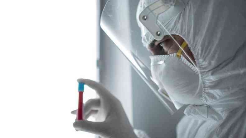 Homem com frasco fazendo análise de sangue em laboratório