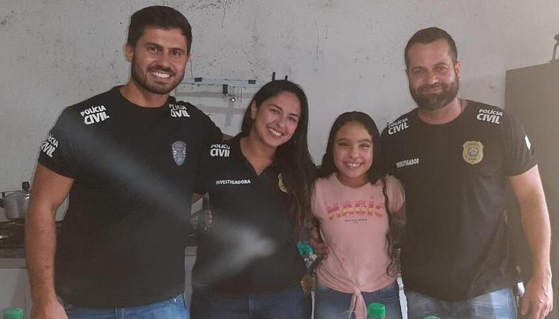 Menina entre trs policiais no aniversrio 