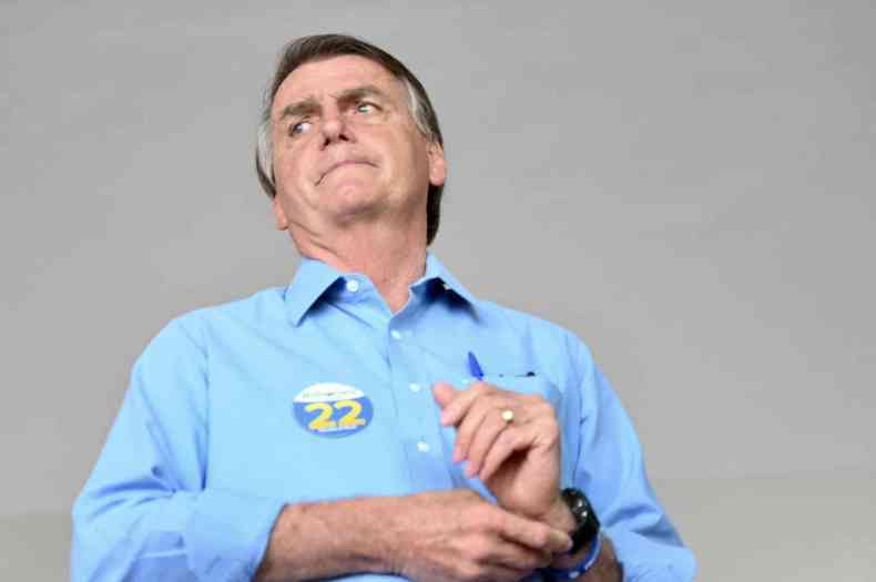 Bolsonaro vestido com camisa azul com adesivo de sua campanha 