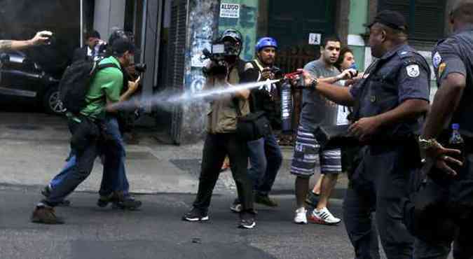 Policial joga spray de pimenta em pessoas na rua no dia da abertura da Copa. Imprensa v abusos(foto: Pilar Olivares/Reuters)