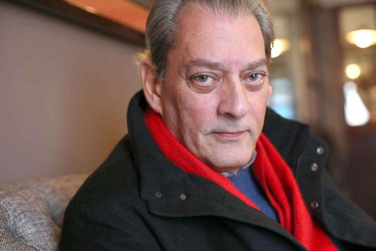 Paul Auster olha para a cmera, usando casaco preto e cachecol preto