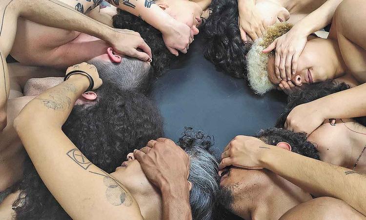 Bailarinos deitados de mos dadas no espetculo Morte vida sonho

