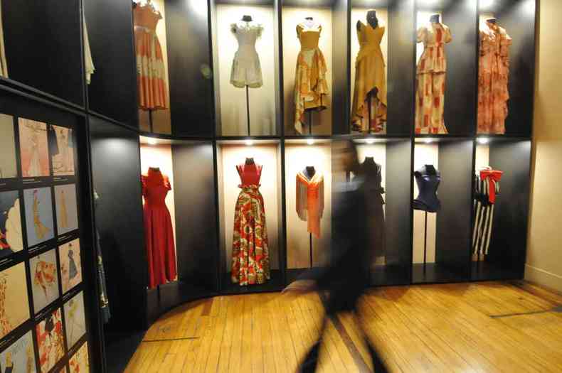 Vestidos expostos em parede iluminada do Museu da Moda, em BH