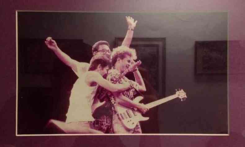 quadro com a foto de Herbert Vianna, com as mos para o alto, Joo Barone, abraando, pelas costas, Bi Ribeiro, que segura a guitarra, durante o Rock in Rio, em 1985