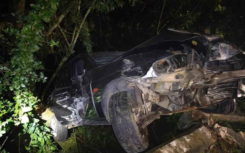 Carro fica suspenso depois de cair de ponte (foto: CBMMG/Reprodução) Carro suspenso por uma árvore