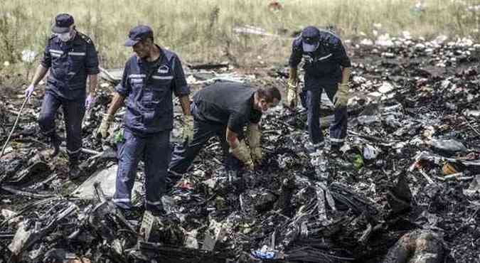 Funcionrios do servio de emergncia da Ucrnia observam destroos da aeronave(foto: BULENT KILIC / AFP)