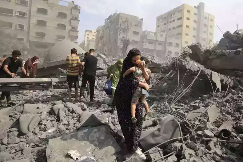 Mulher palestina com criana no colo evacua regio alvo de ataques de resposta de Israel