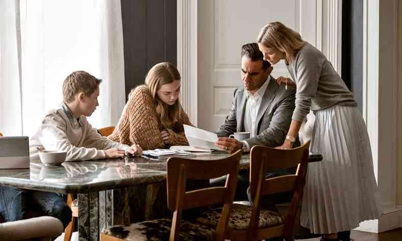 Os atores Naomi Watts (Nora), Bobby Cannavale (Dean Brannock), Isabel Gravitt (Ellie) e Luke David Blumm (Carter) leem carta em torno de uma mesa, em cena de 'Bem-vindos  vizinhana'