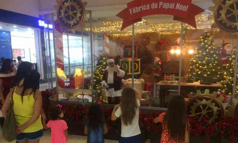 Crianças acenam para Papai Noel isolado em estrutura, no Shopping Uberaba