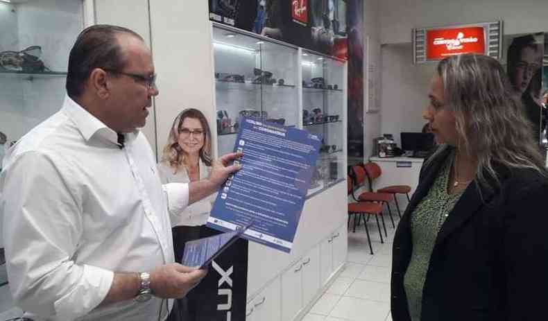 O presidente da CDL-BH, Marcelo de Souza e Silva, entrega material informativo aos lojistas(foto: Jair Amaral/EM/DA PRESS)