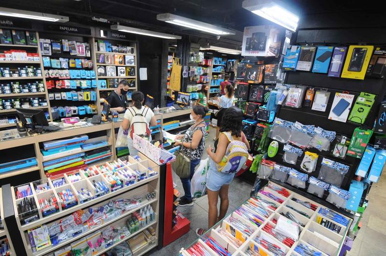Loja de materiais escolares com clientes e produtos expostos