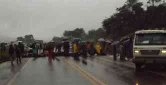 Mesmo com a chuva, os moradores da ocupao permanecem interditando a estrada com pneus(foto: Guilherme Assis/Dirio de Baro )