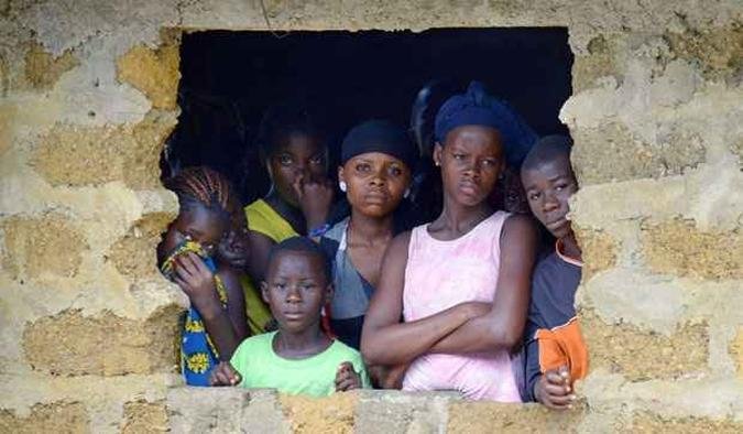 Vizinhos observam corpo de v�tima do Ebola ser retirado; ONU est� criando um Centro de Crise com a meta de interromper a transmiss�o em pa�ses afetados(foto: AFP PHOTO / DOMINIQUE FAGET )