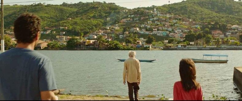 Em 'Sol', o sertão baiano leva um pouco de calor às vidas de Teo, Teodoro e Duda(foto: Paris Filmes/divulgação) Três atores estão de costas diante do rio e de uma cidade do sertão em cena do filme Sol