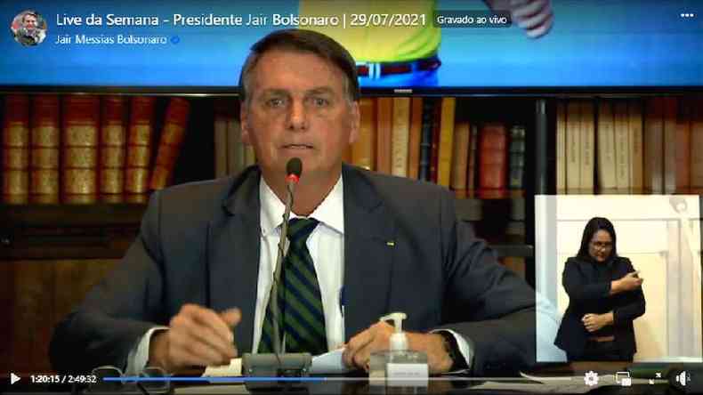 Reproduo de vdeo no Facebook mostra Bolsonaro, sentado, falando no microfone com livros atrs