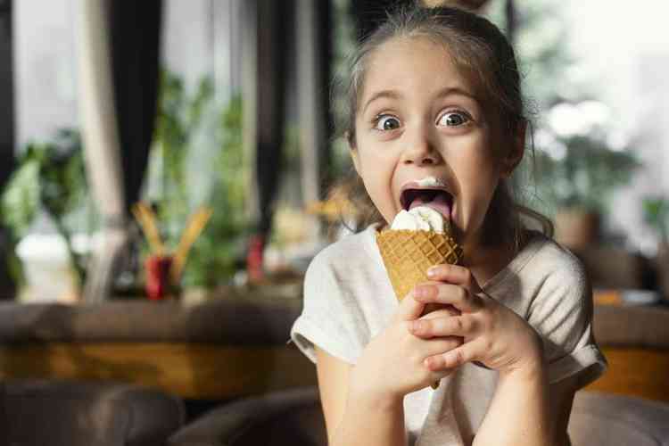Menina feliz comendo sorvete de casquinha