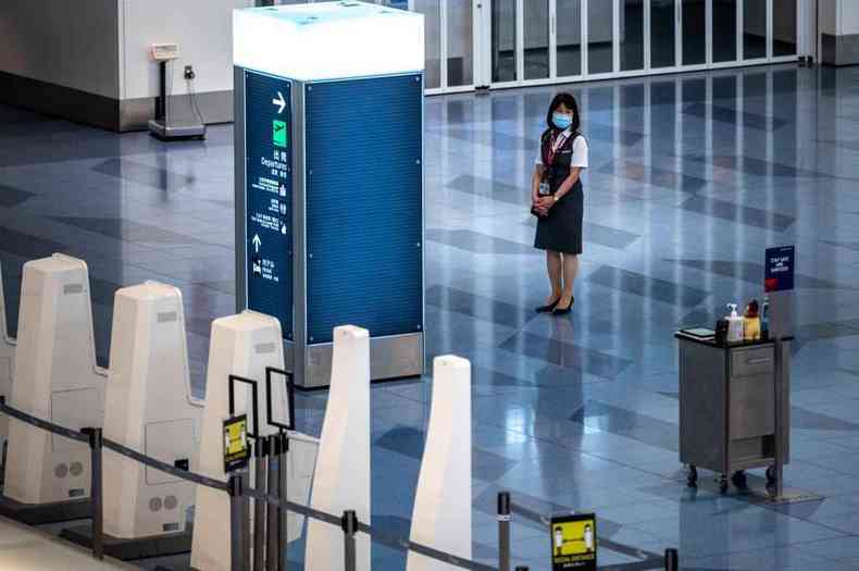 Membro de companhia aérea sozinha em área de embarque de aeroporto em Tóquio