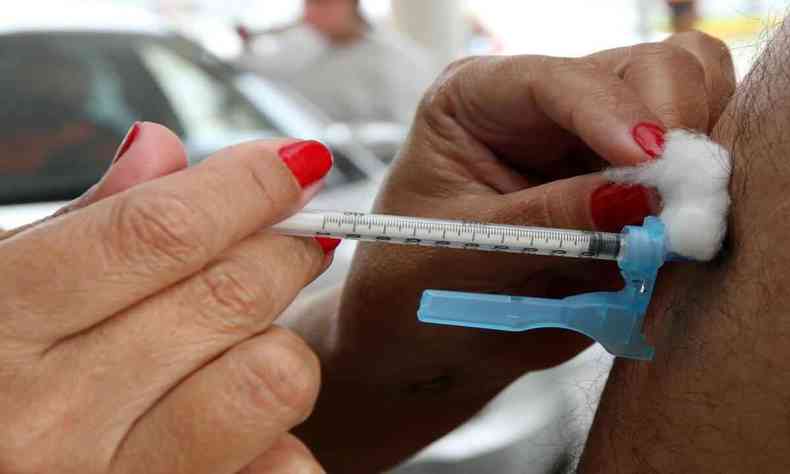 Pessoa sendo imunizada por profissional de saúde