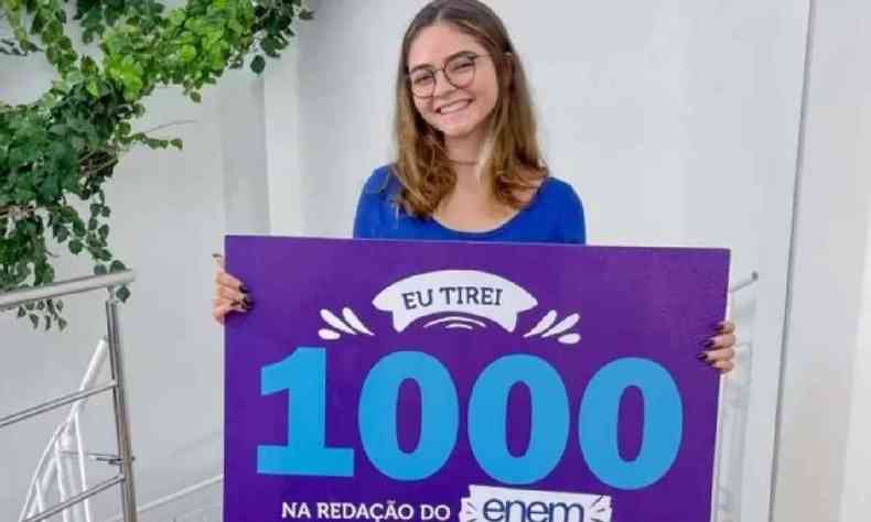 Fernanda Karolinne segurando uma placa rocha com o nmero mil