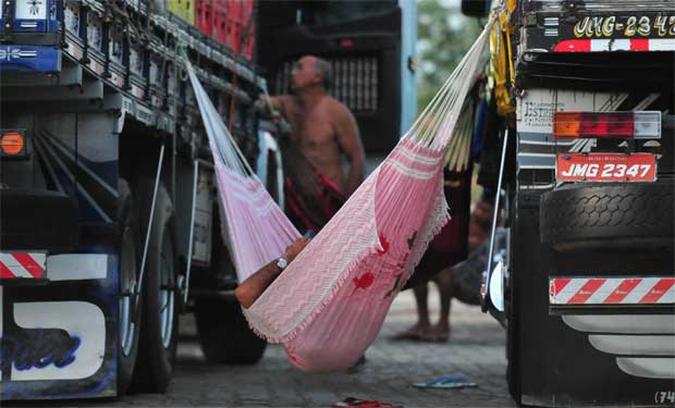 Com a rede esticada entre as carrocerias de dois caminhões,motorista aproveita para dormir em cama improvisada em uma parada da rodovia na região de Ouricuri, no Sertão de Pernambuco(foto: Alexandre Guzanshe/EM/D.A Press) Com a rede esticada entre as carrocerias de dois caminhões,motorista aproveita para dormir em cama improvisada em uma parada da rodovia na região de Ouricuri, no Sertão de Pernambuco(foto: Alexandre Guzanshe/EM/D.A Press)