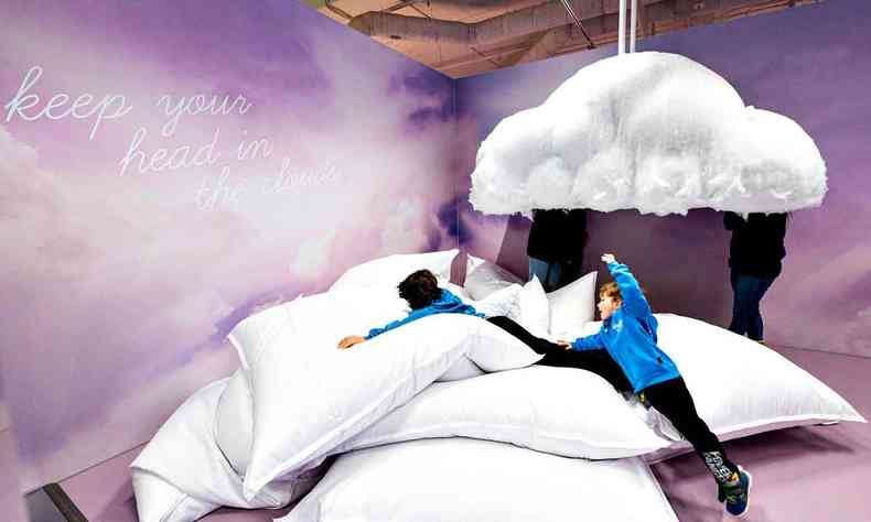 duas crianas brincam em almofadas brancas gigantes que simulam nuvens no Youseum 
